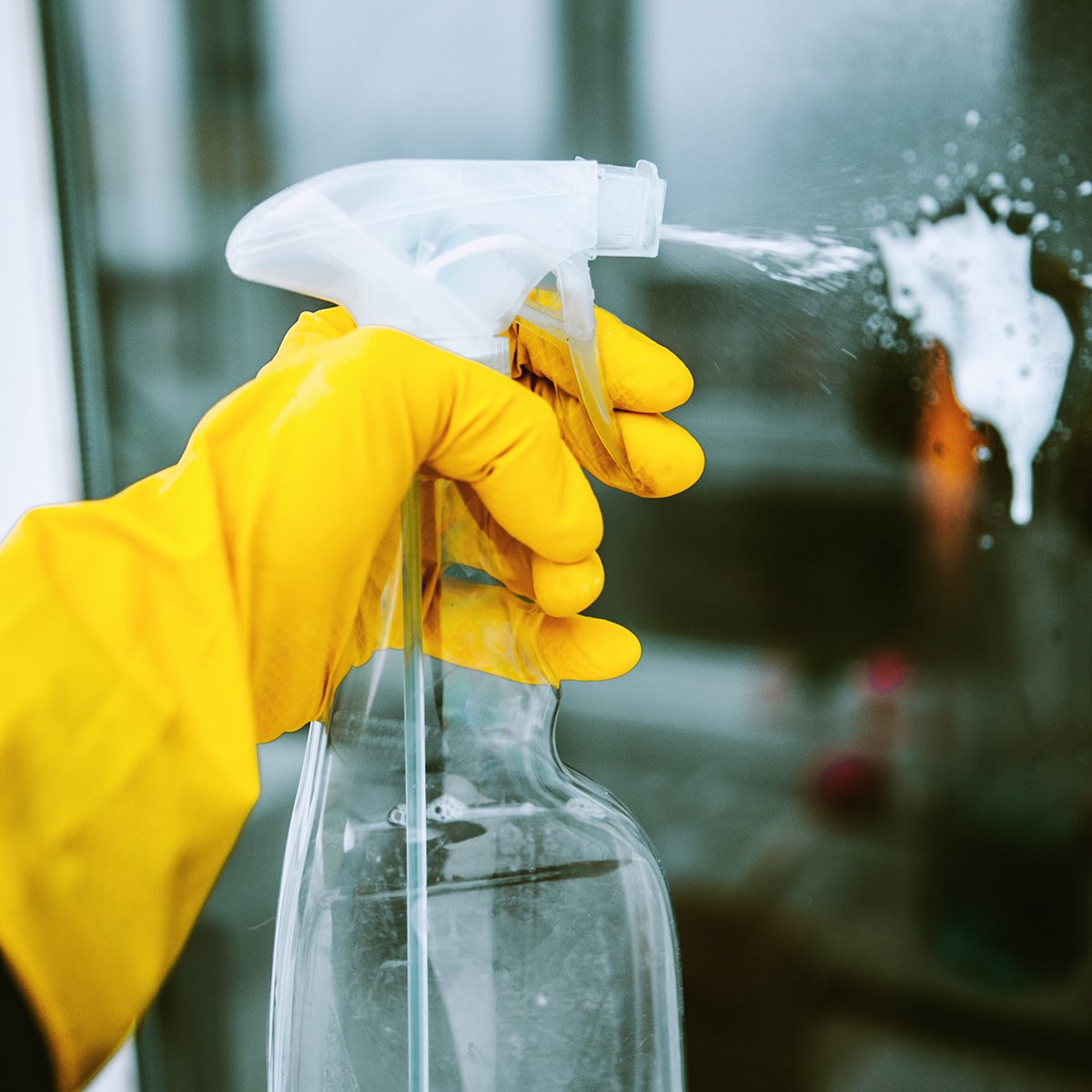 Hands with napkin cleaning window. Washing the glass on the windows with cleaning spray