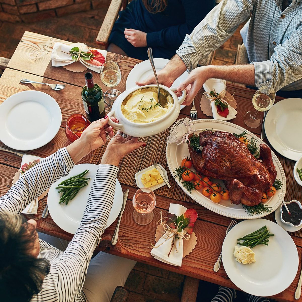 Cropped shot mash being passed during a feast at a dining table
