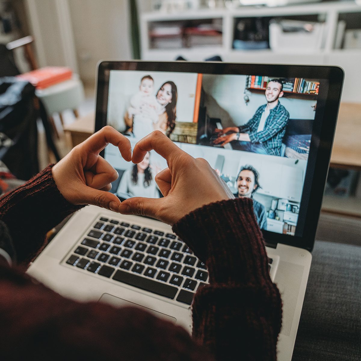 Young woman using a laptop to connect with her friends and parents during quarantine. She