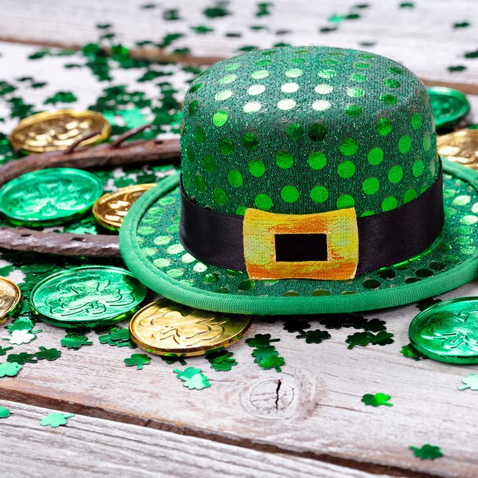 Close Up Of Coins With Horseshoe And Hat On Wooden Table