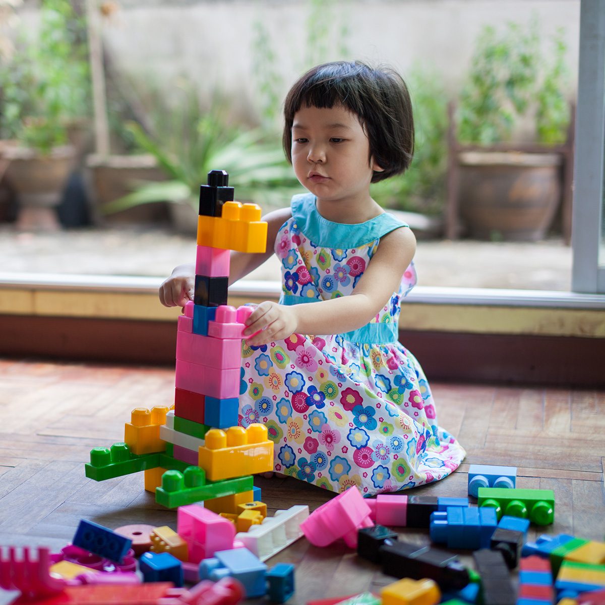 Little girl is playing with building bricks