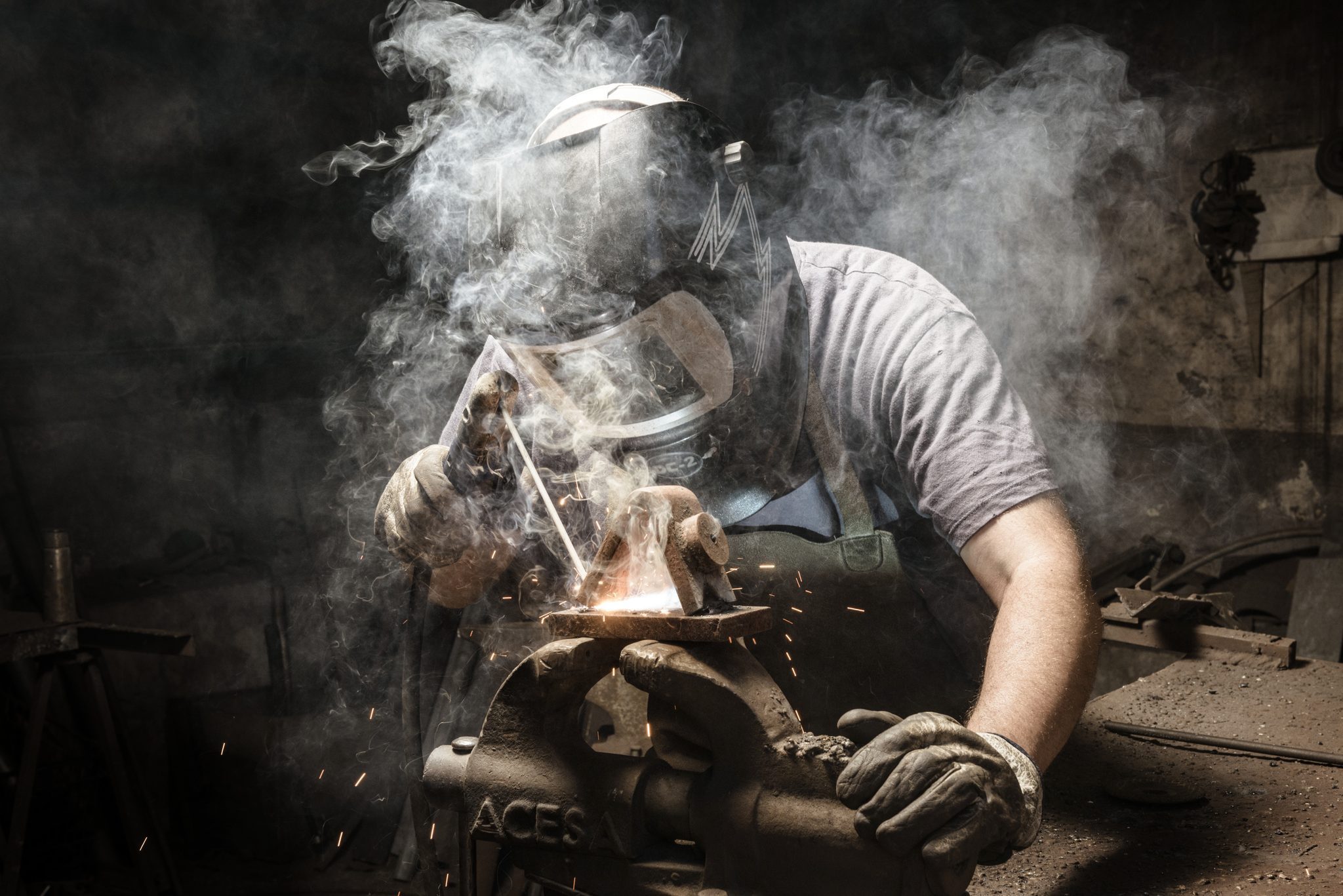 a welder working with metal fumes surrounding him
