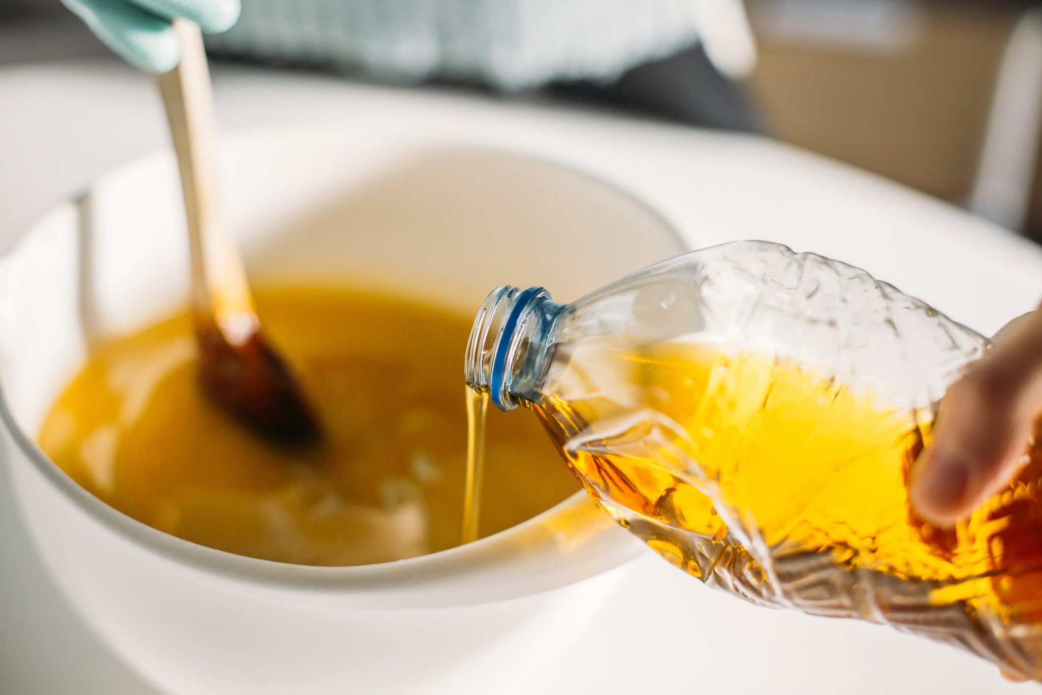 pouring canola oil into a bowl for baking