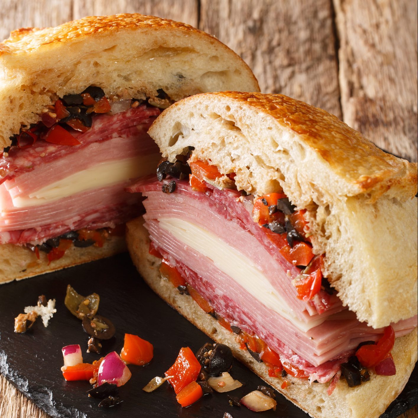 Muffaletta Sandwich with Homemade Bread and Olive Salad close-up on the table