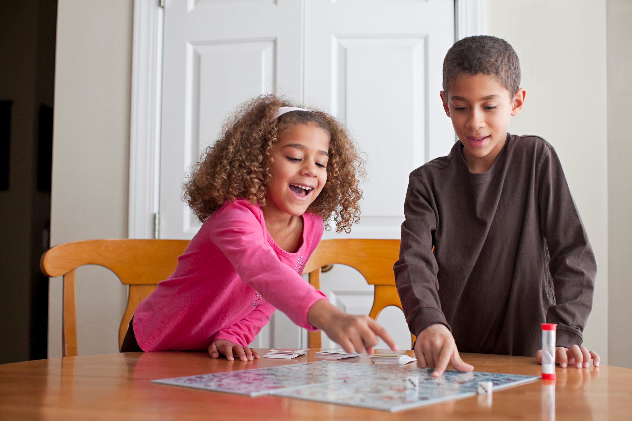 Mixed race children playing board game together