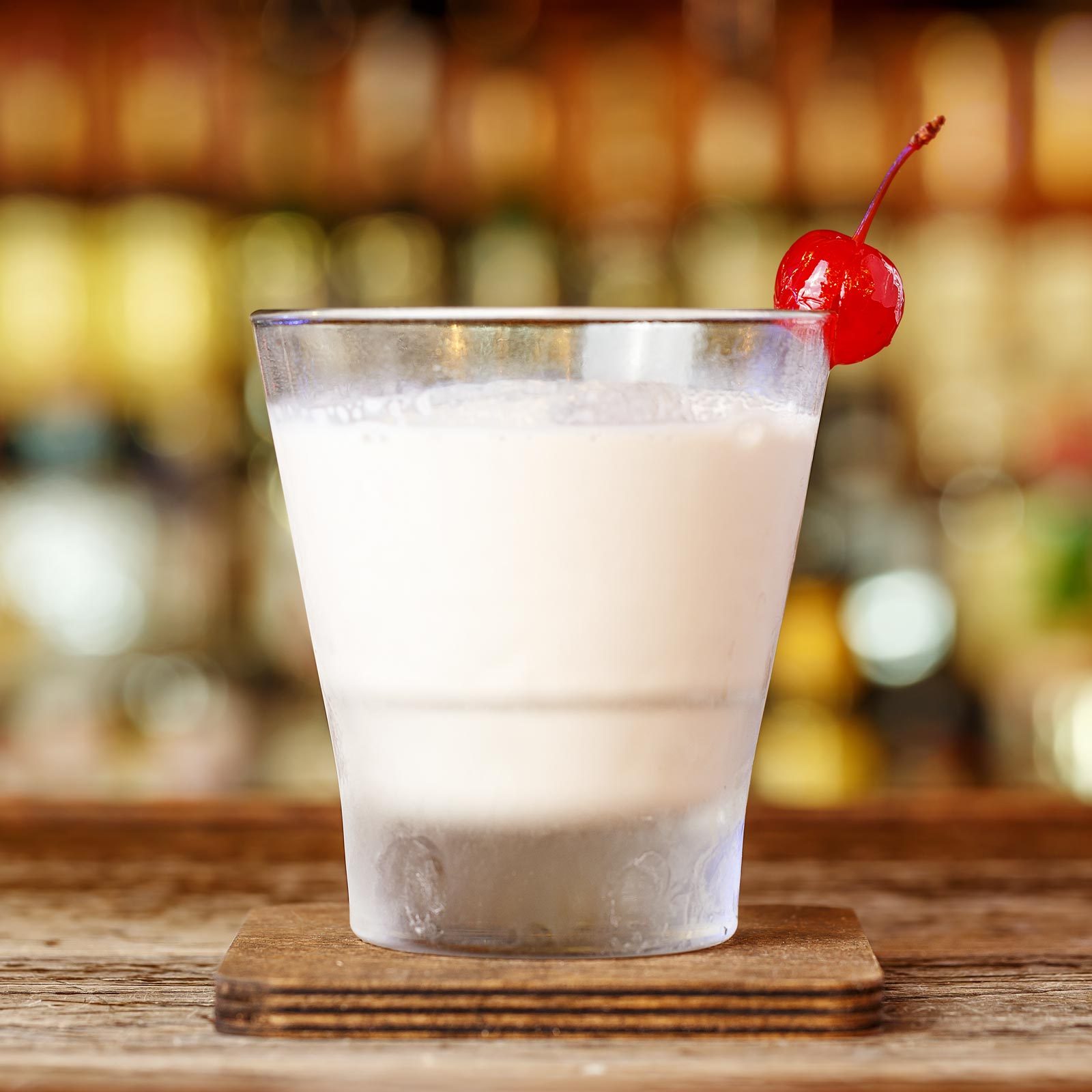 King cake shot with a cherry on a bar table