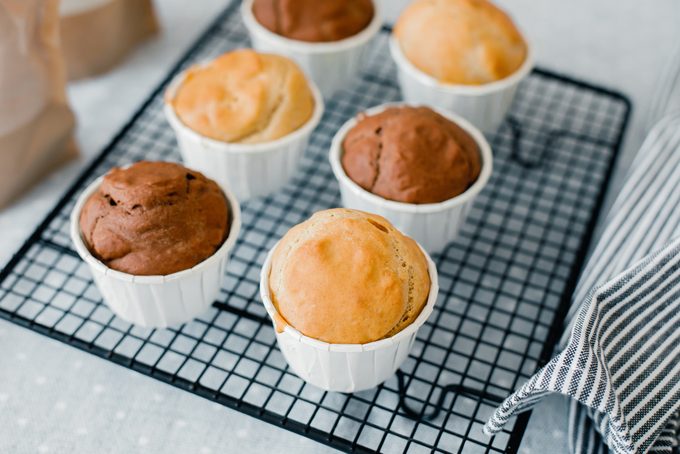 Homemade vanilla and chocolate gliten free and sugar free muffins on cooling rack on kitchen table