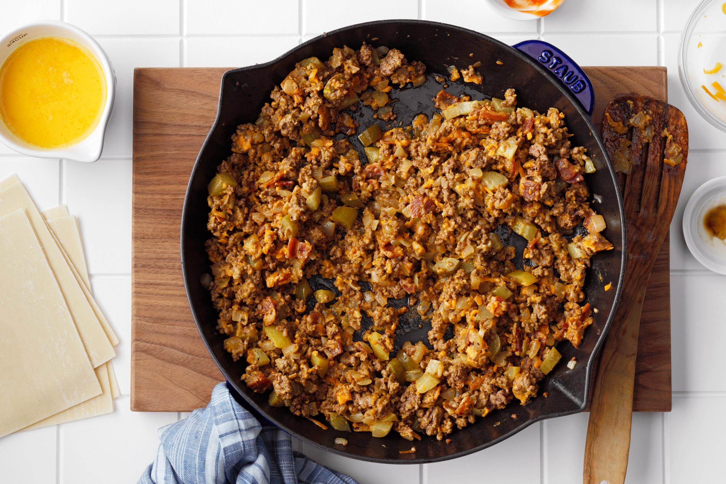 top view of a skillet with cheeseburger egg roll filling