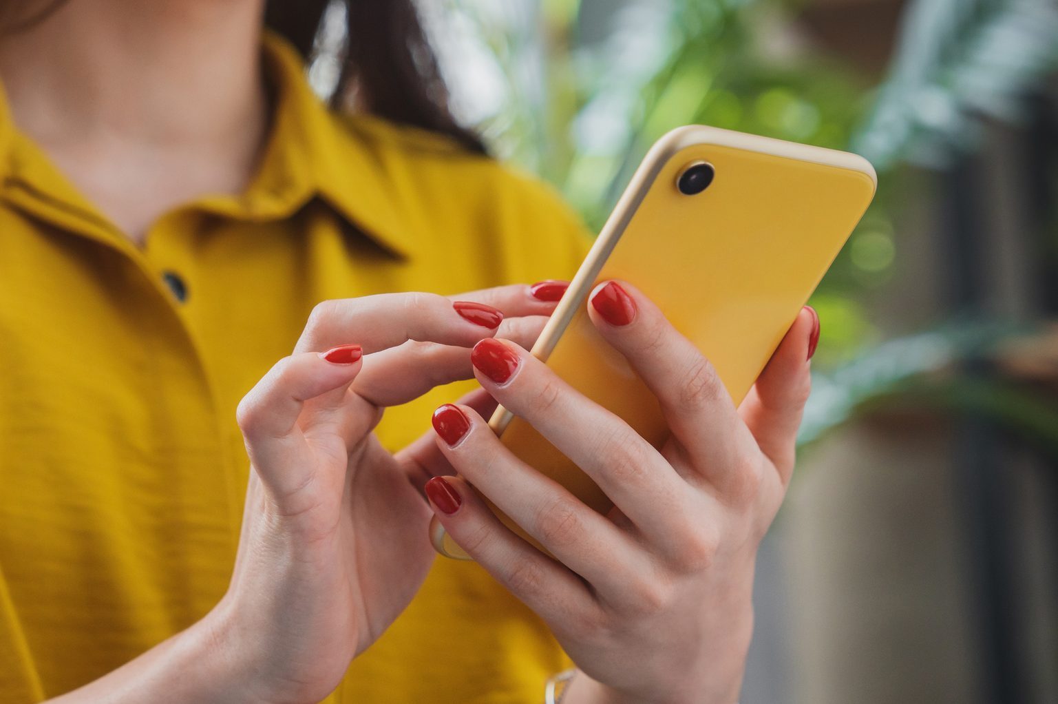Cropped image of happy girl using smartphone device while chilling at home