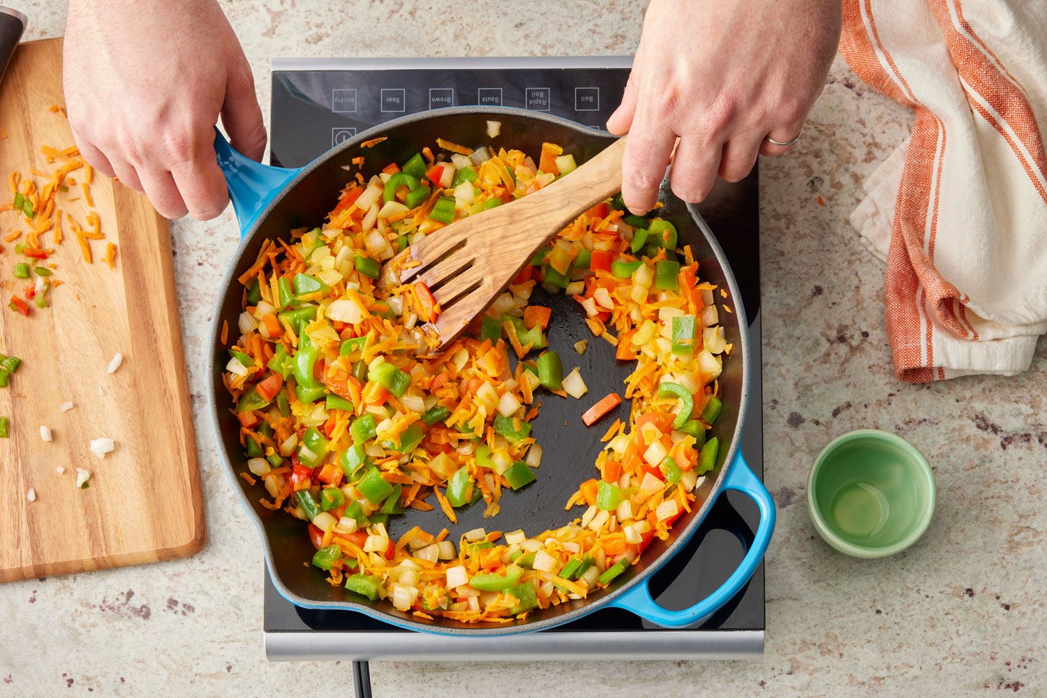 hands sautéing the vegetables for lentil sloppy joes