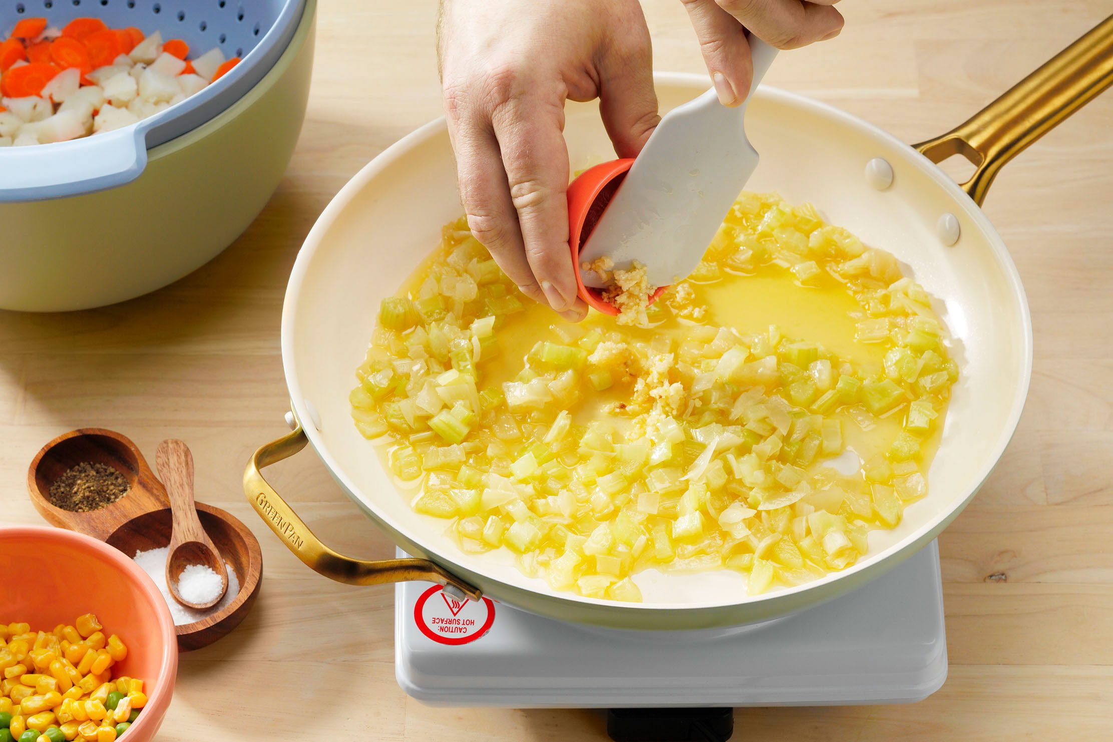 Vegan Potpie Showing Garlic Being Added To Potato Carrot Mixture.