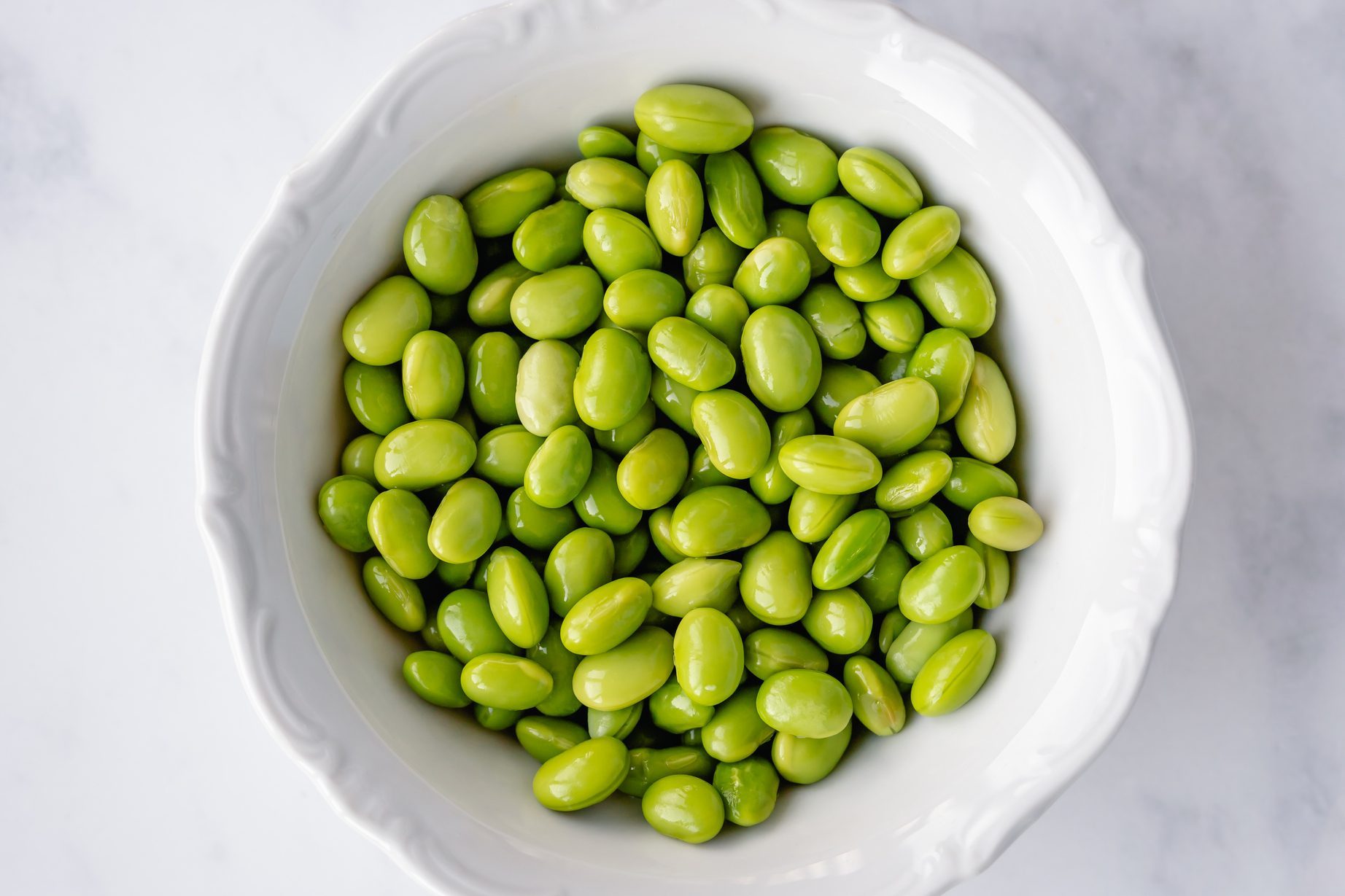 Overhead view of a bowl of shelled edamame beans