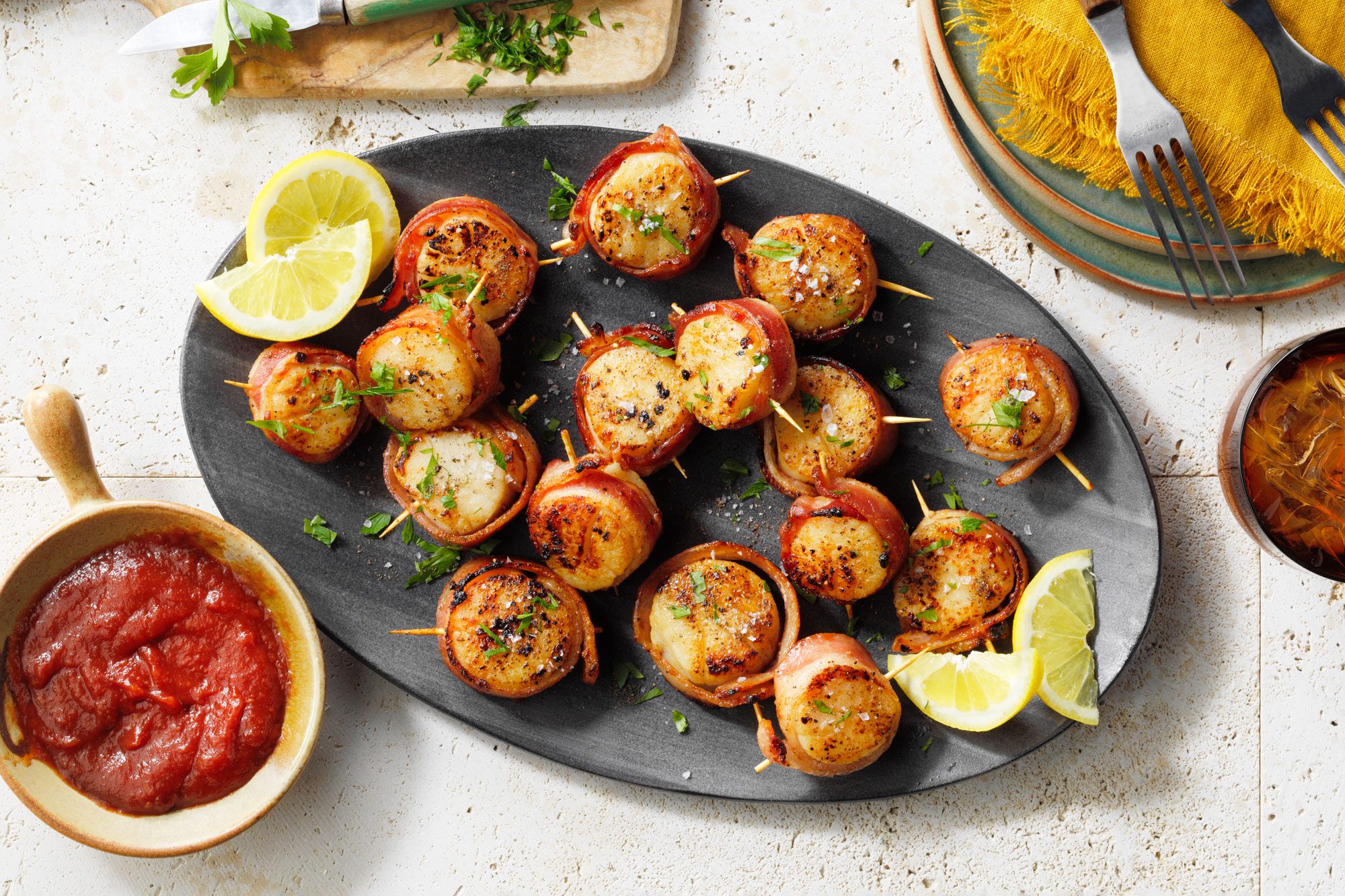 Bacon Wrapped Scallops on a black serving platter