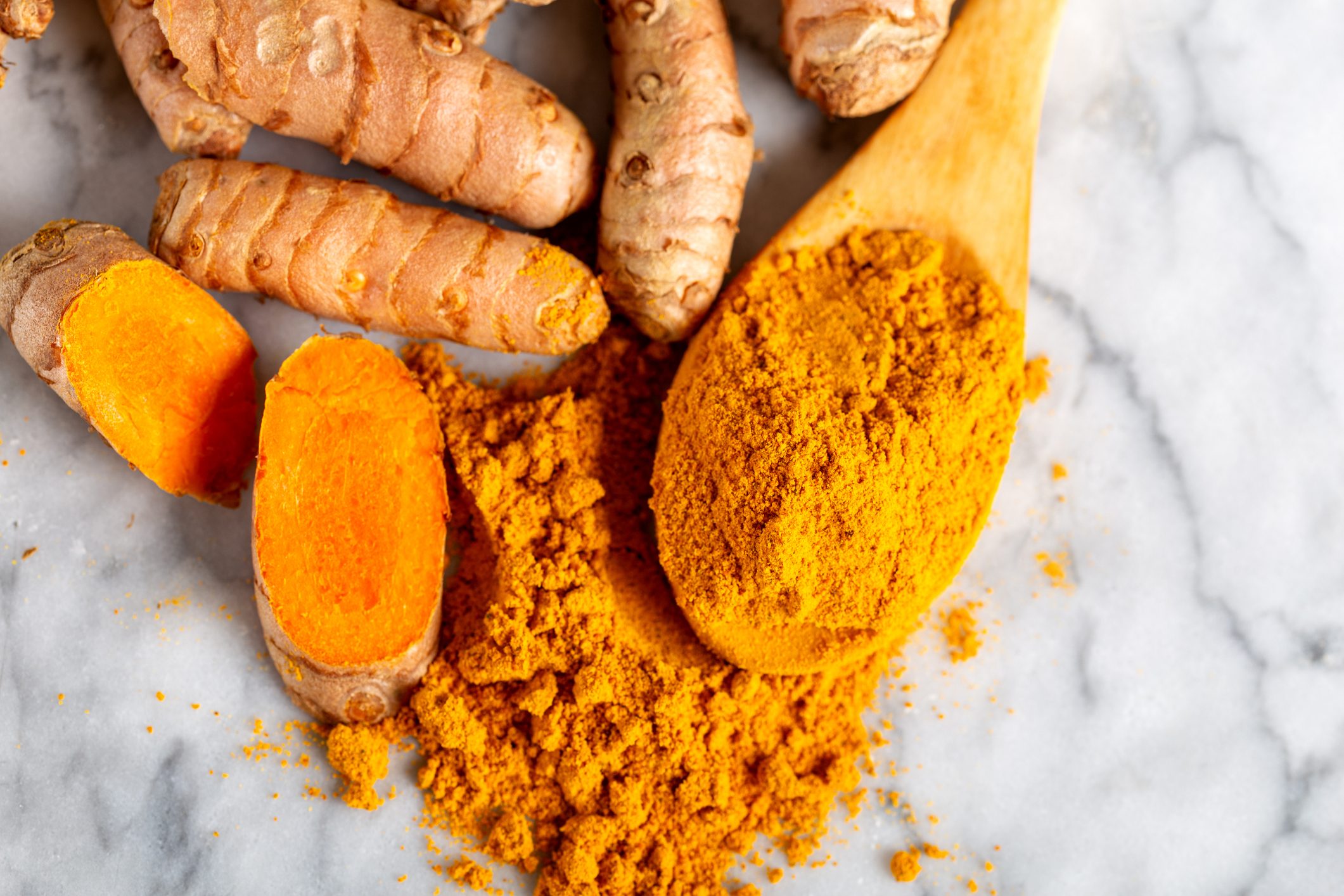 Food and drink, diet nutrition, health care concept. Raw organic orange turmeric root and powder, curcuma longa on a grunge cooking table. Indian oriental low cholesterol spices