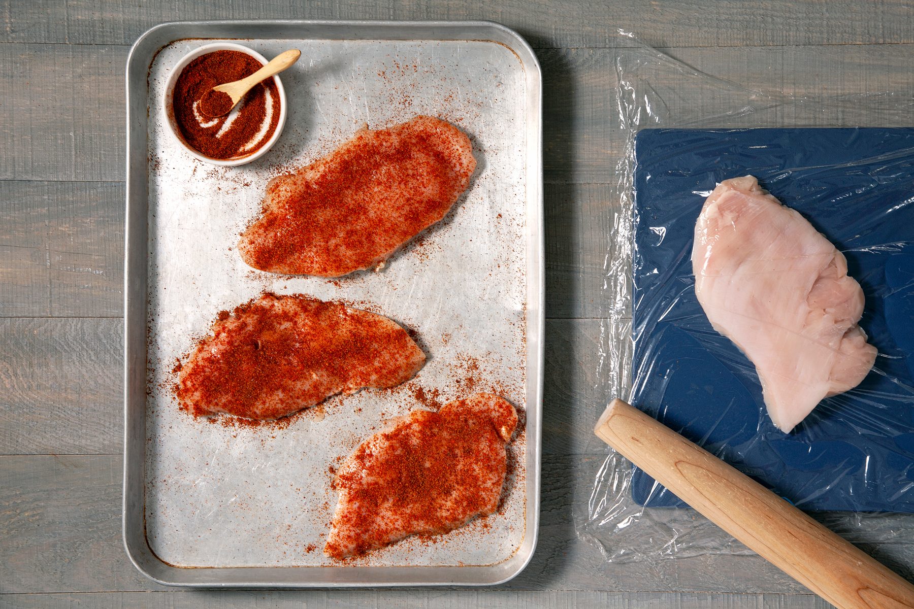 Spice mixture sprinkled over the raw chicken breasts