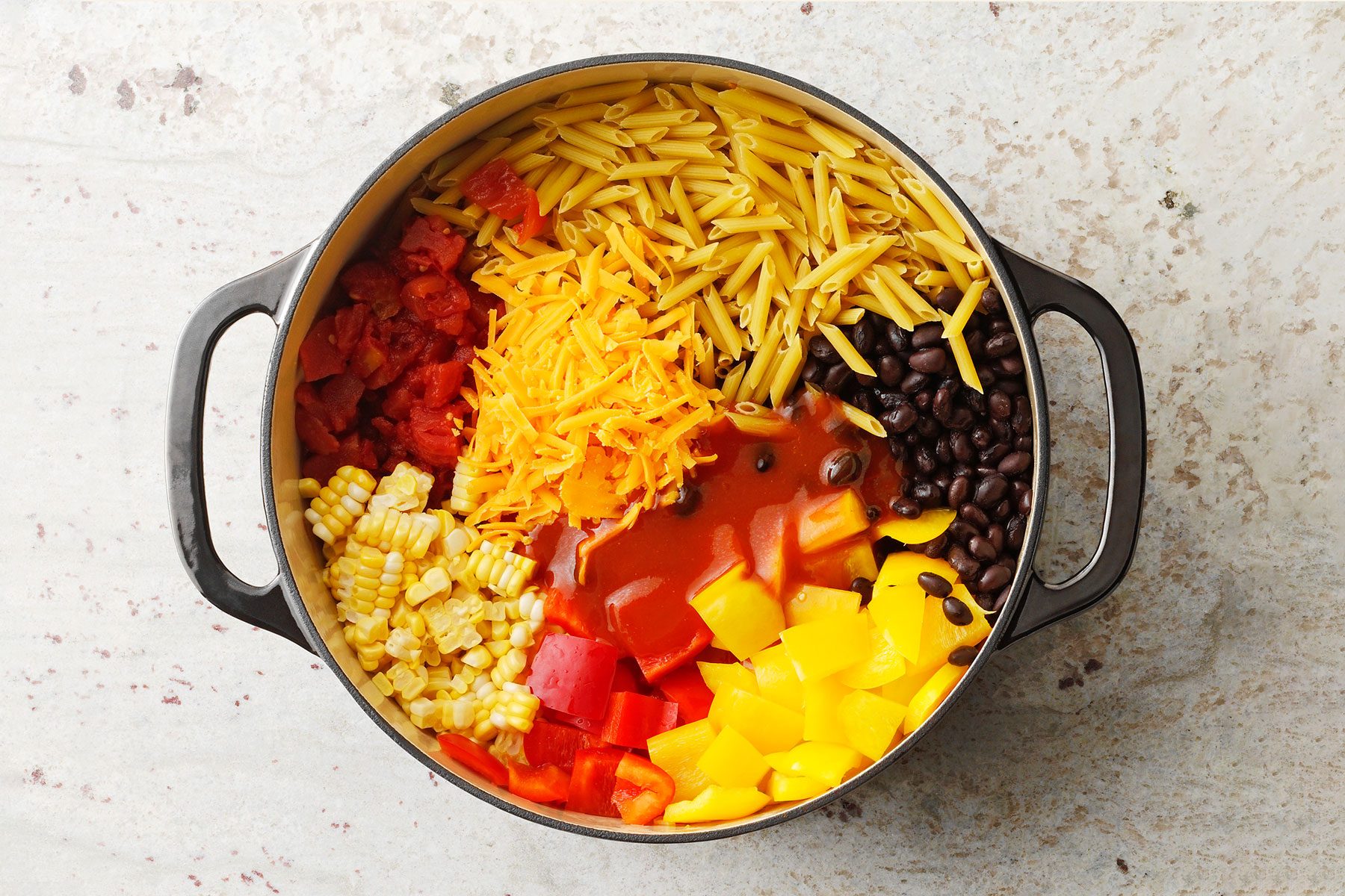 Raw pasta and vegetable in a large pot