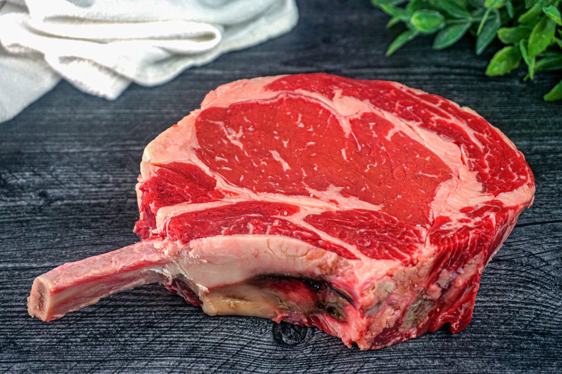 Raw Cowboy steaks on a kitchen table