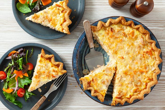 Two plates with a quiche and salad on them