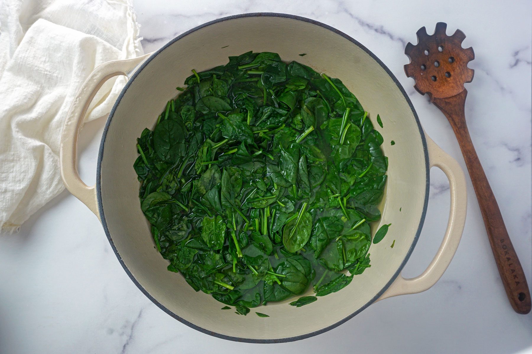Spinach inside the stock pot to make swamp soup