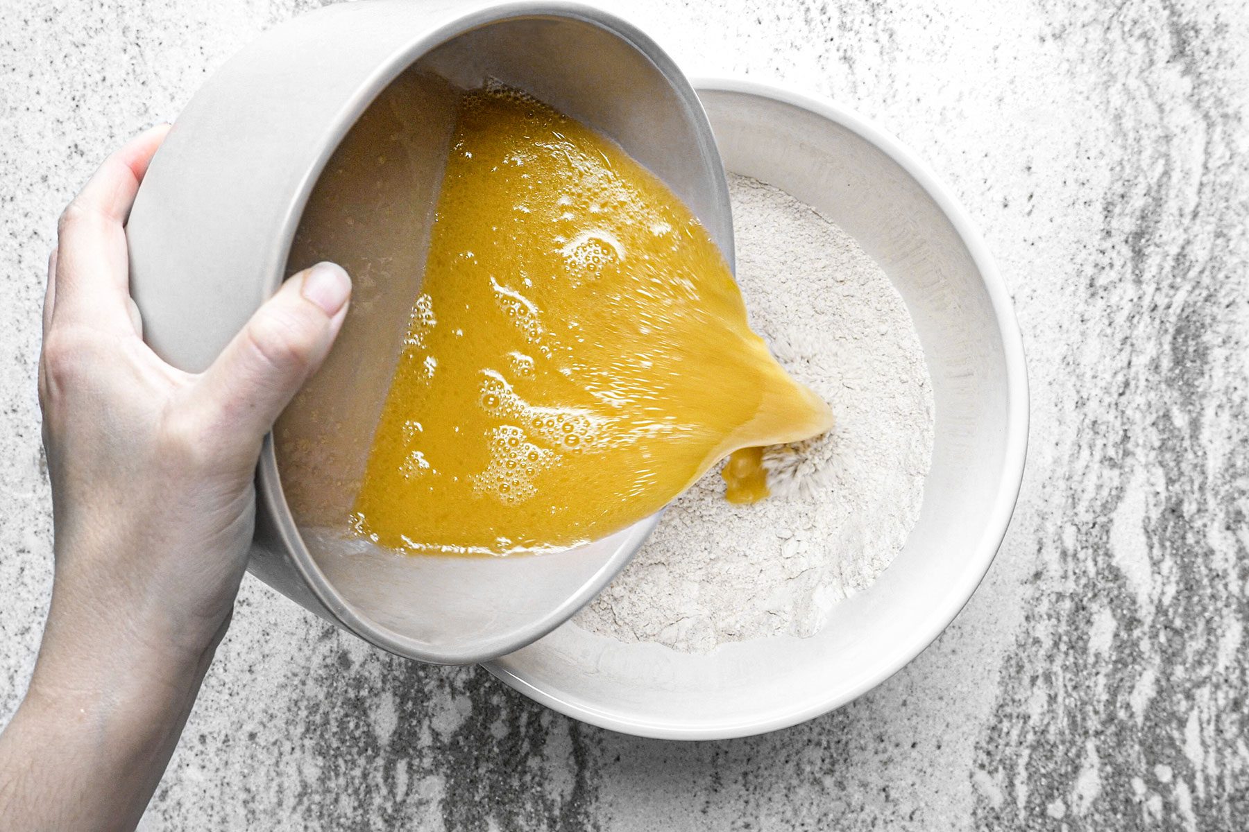 Whisking wet ingredients with dry ingredients in a bowl