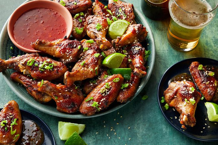 Asian Chicken Wings served on plate with sauce and lemon wedges