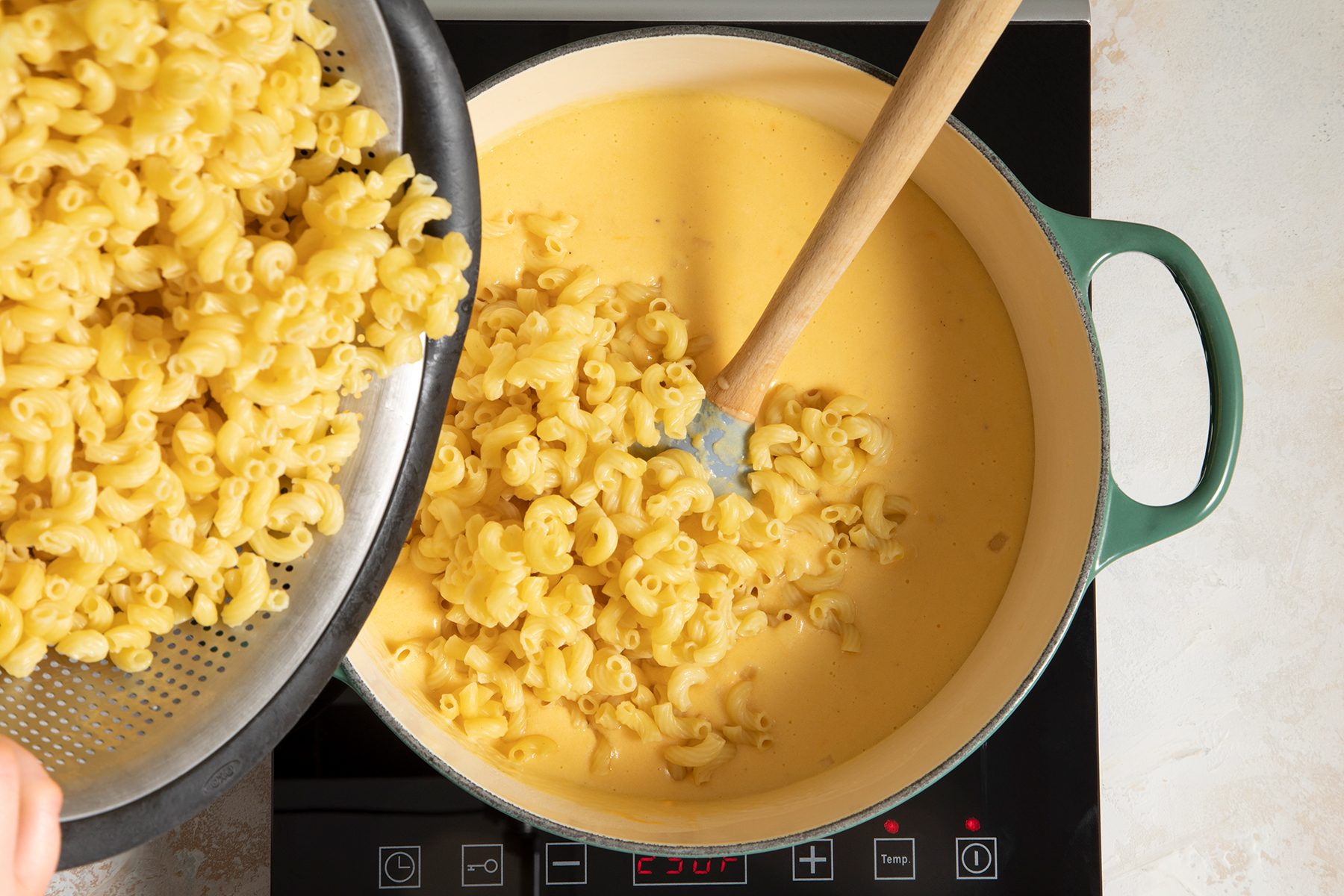 Adding macaroni in dutch oven for Baked Mac and cheese recipe
