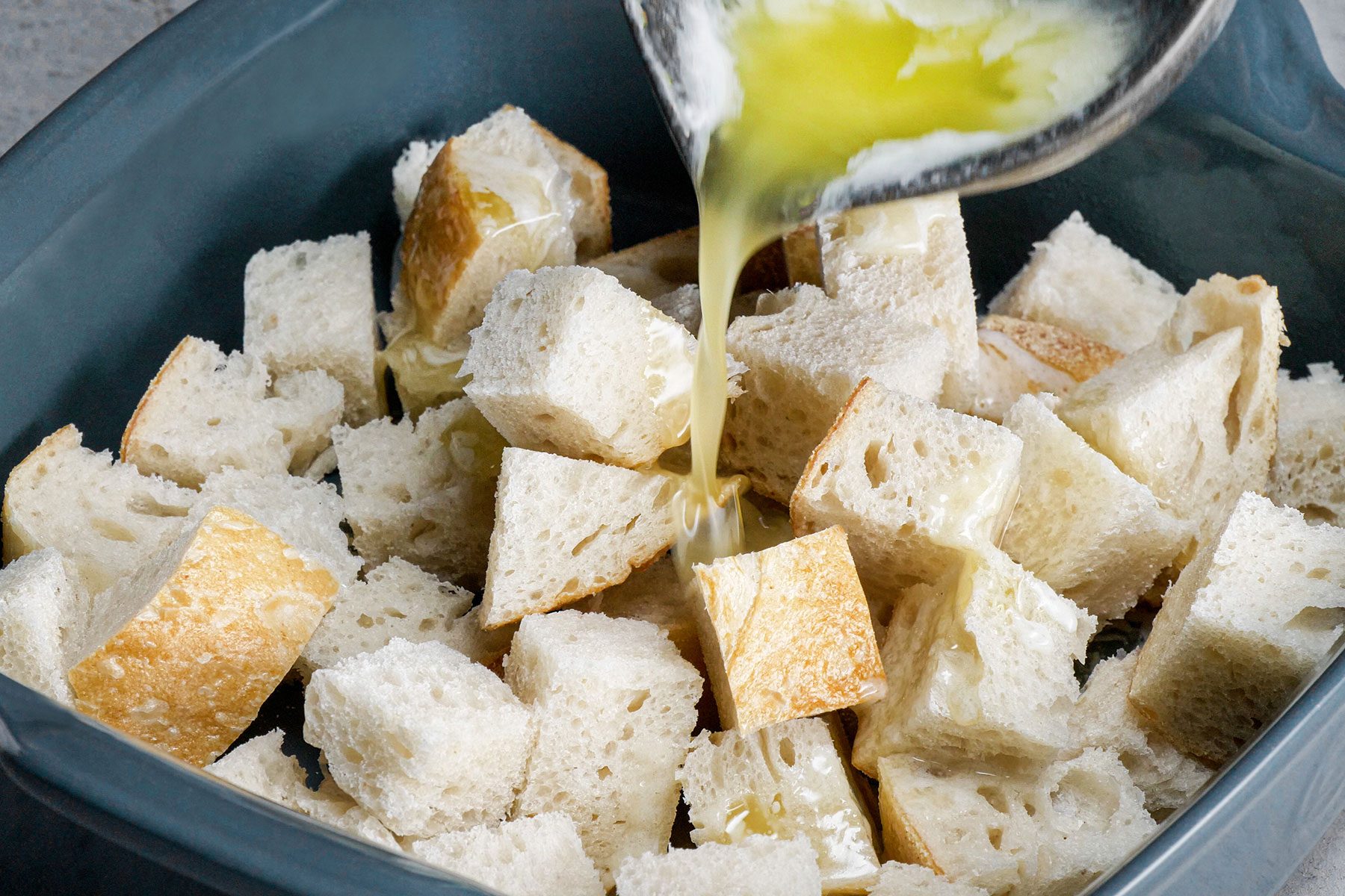 Pouring Melted Butter on Cubes of Bread