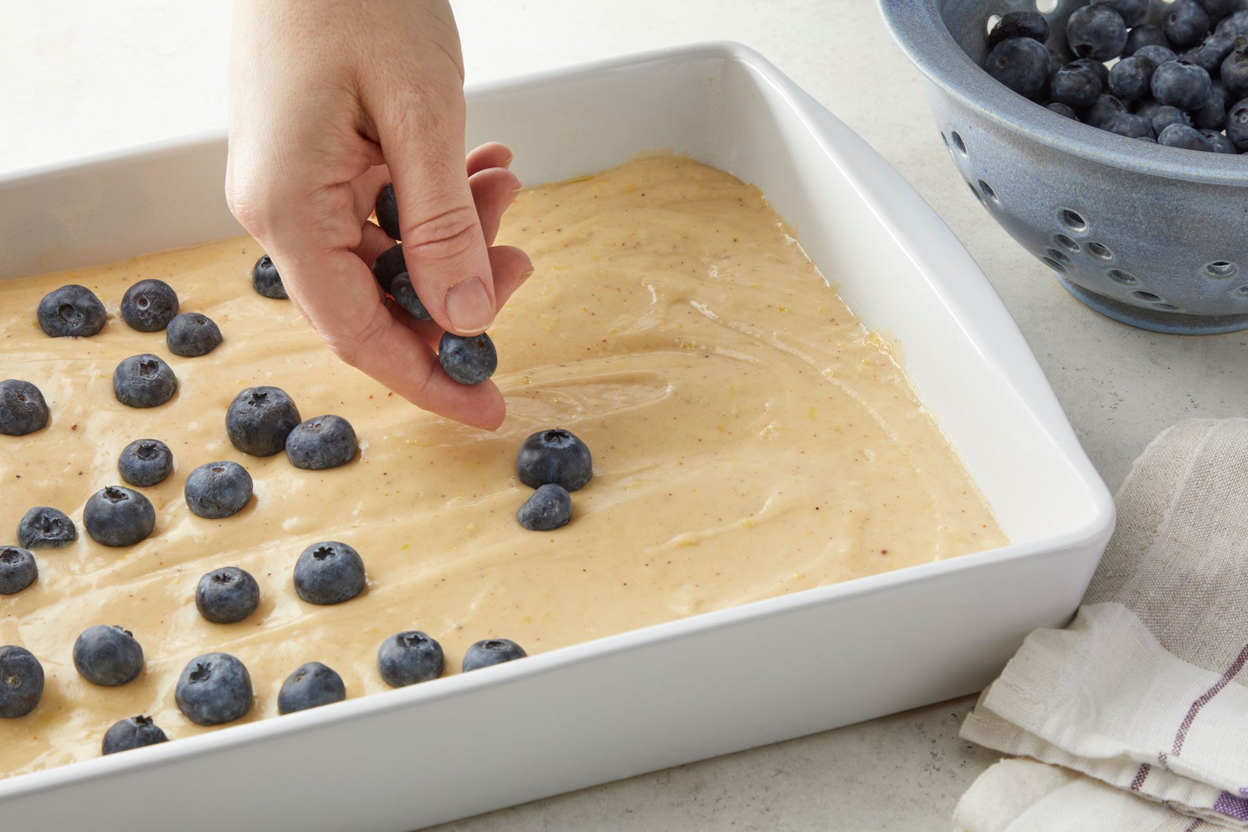 Scatter the blueberries on the batter in a large baking pan.