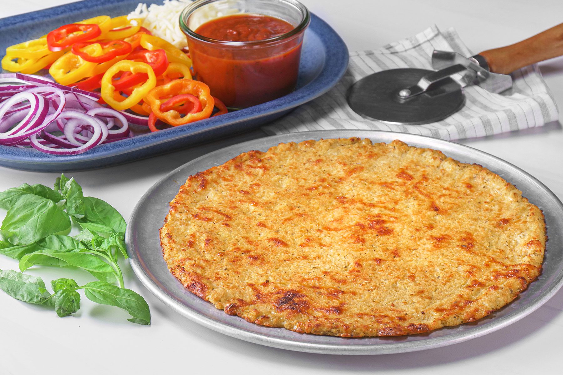 Cauliflower Pizza Crust served on plate with vegetables on side