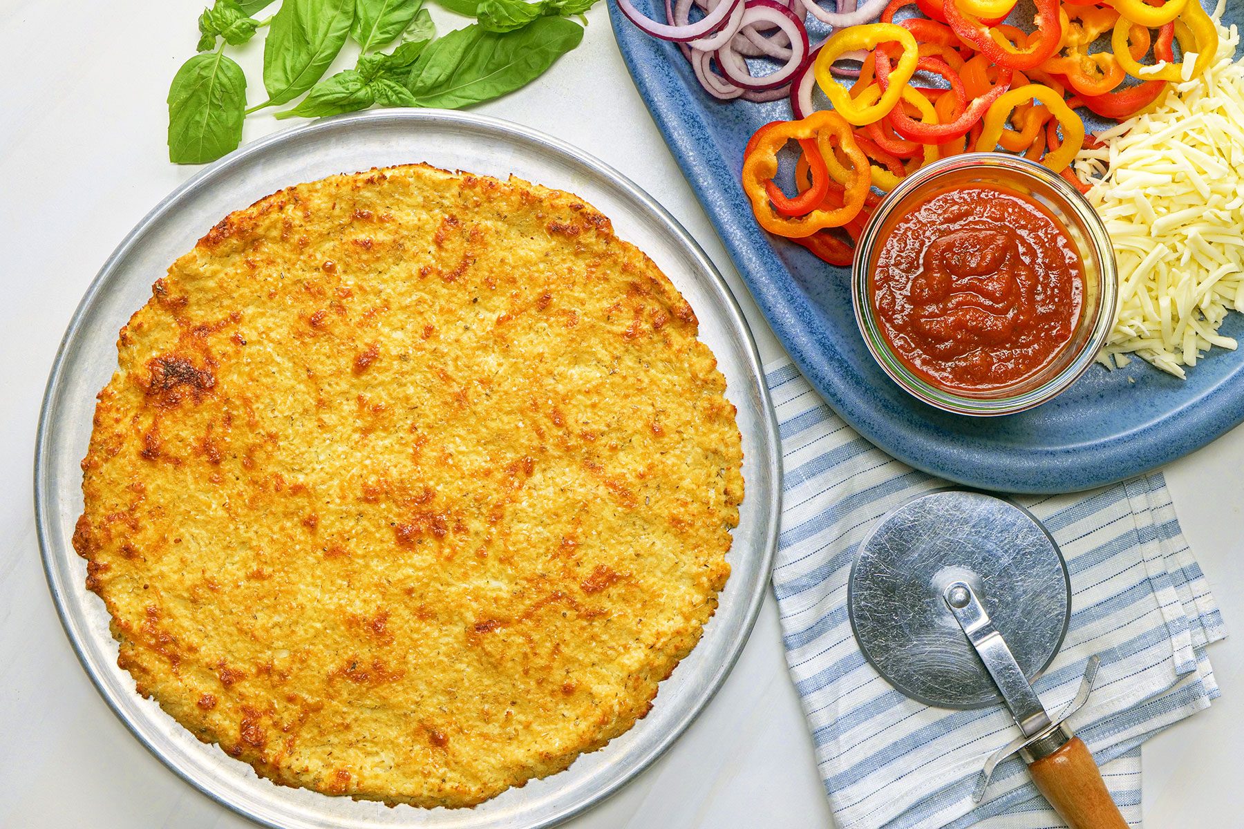 Cauliflower Pizza Crust served on plate with vegetables on side 