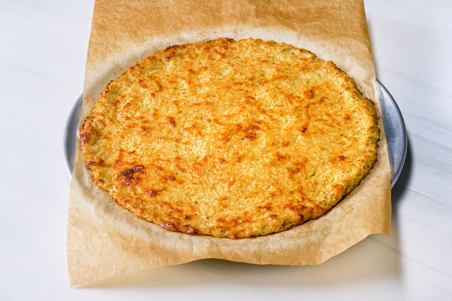 Cauliflower Pizza Crust on parchment paper