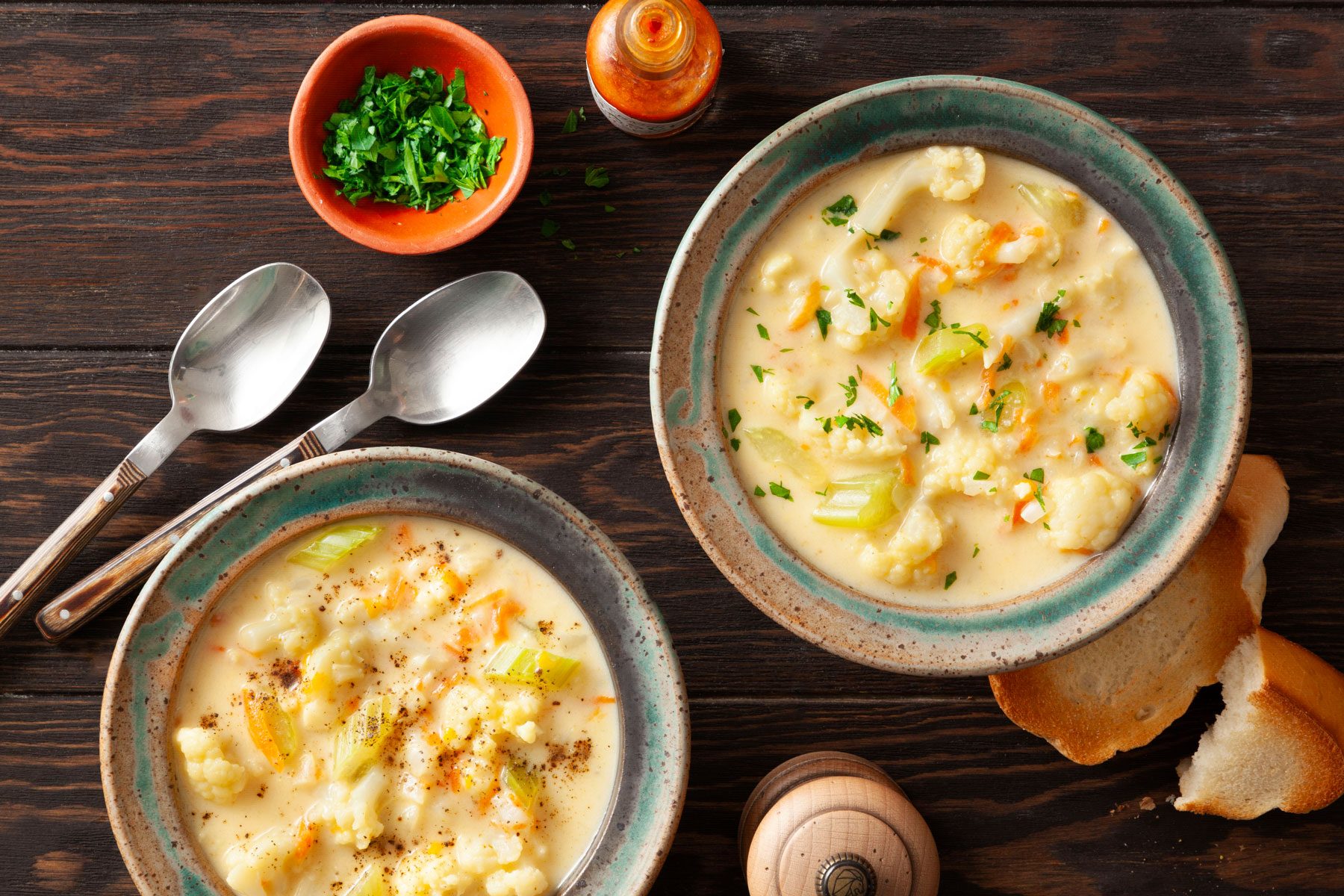 Cauliflower Soup i plates with beads and spoons on the side