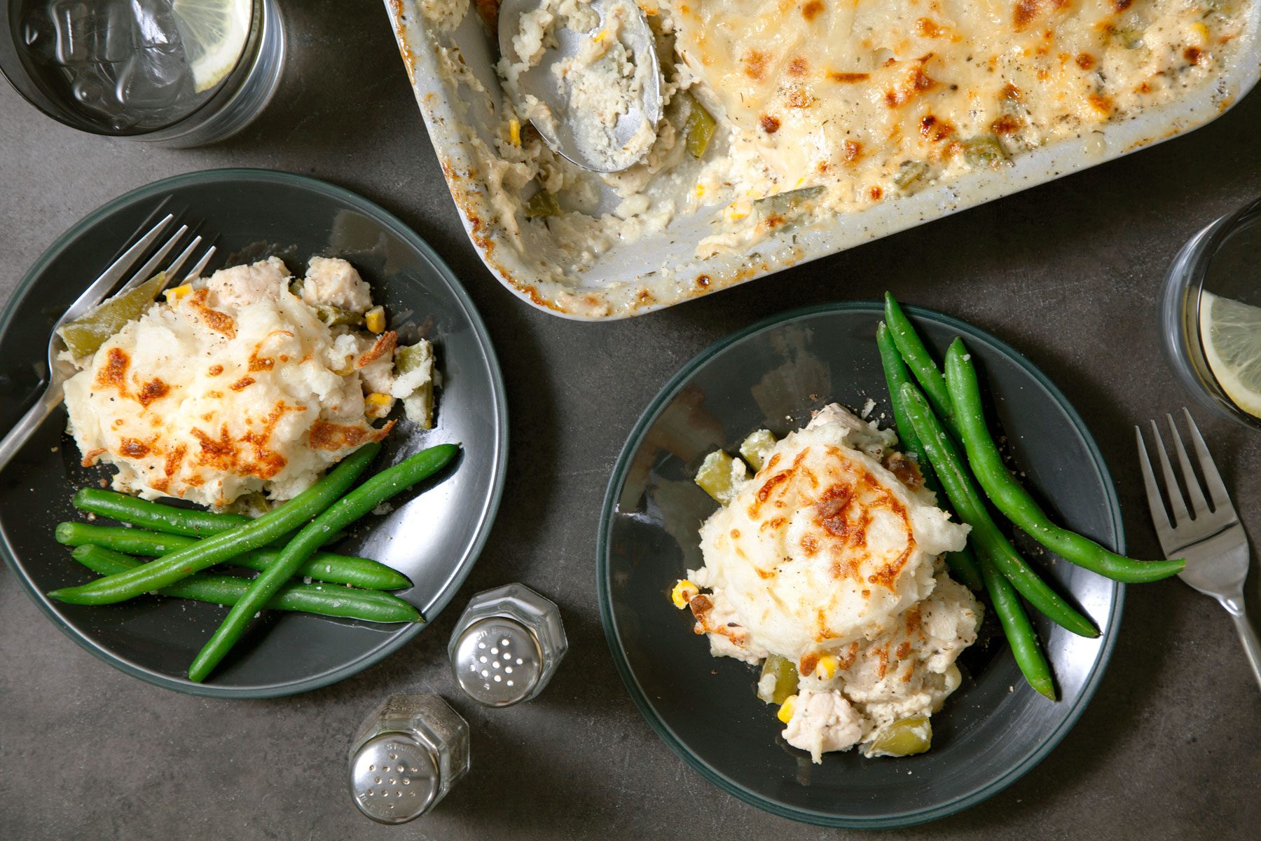 Chicken Shepherds Pie served in plates with vegetables on side