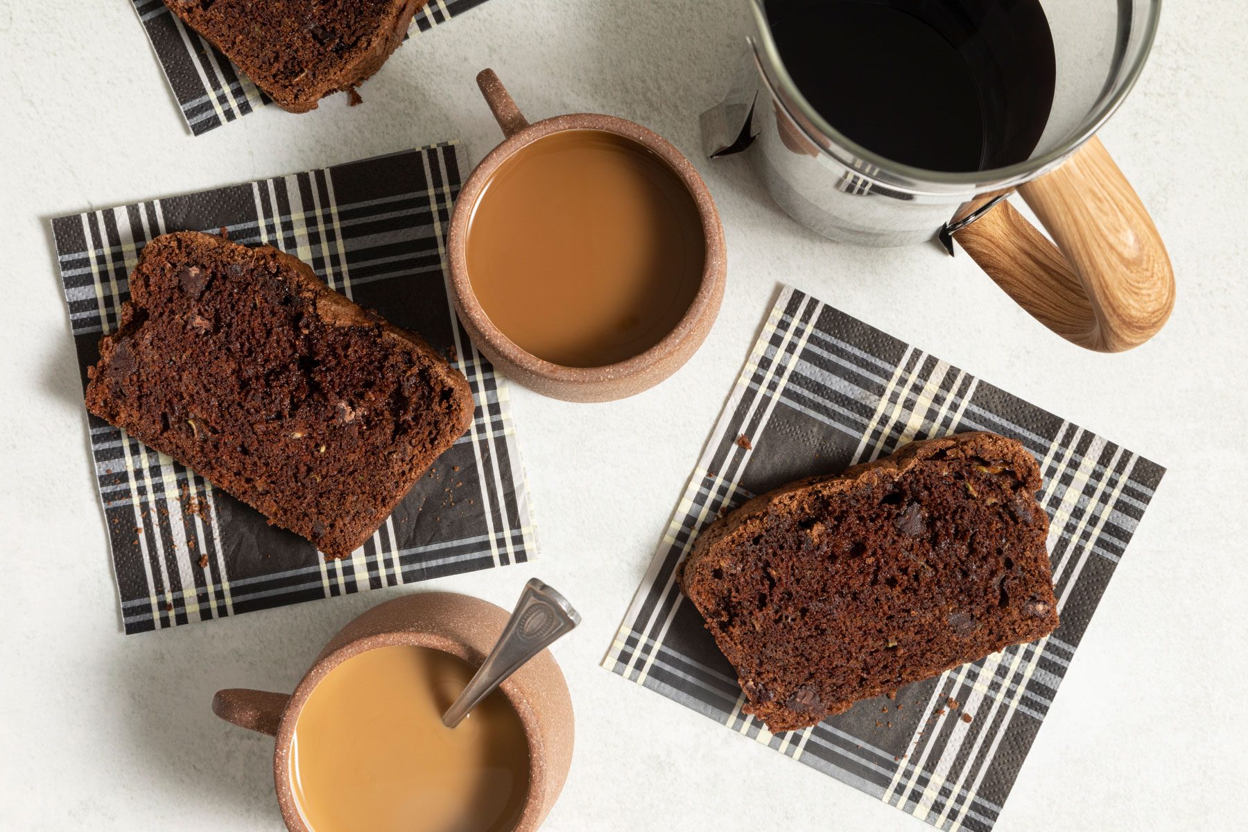 Chocolate Zucchini Bread served with tea on a white marble countertop.