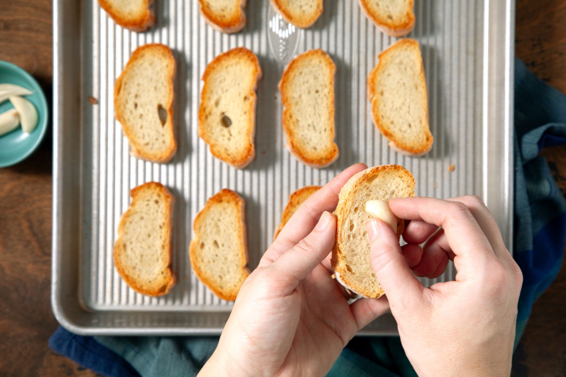 Rubbing the toasts with the halved garlic