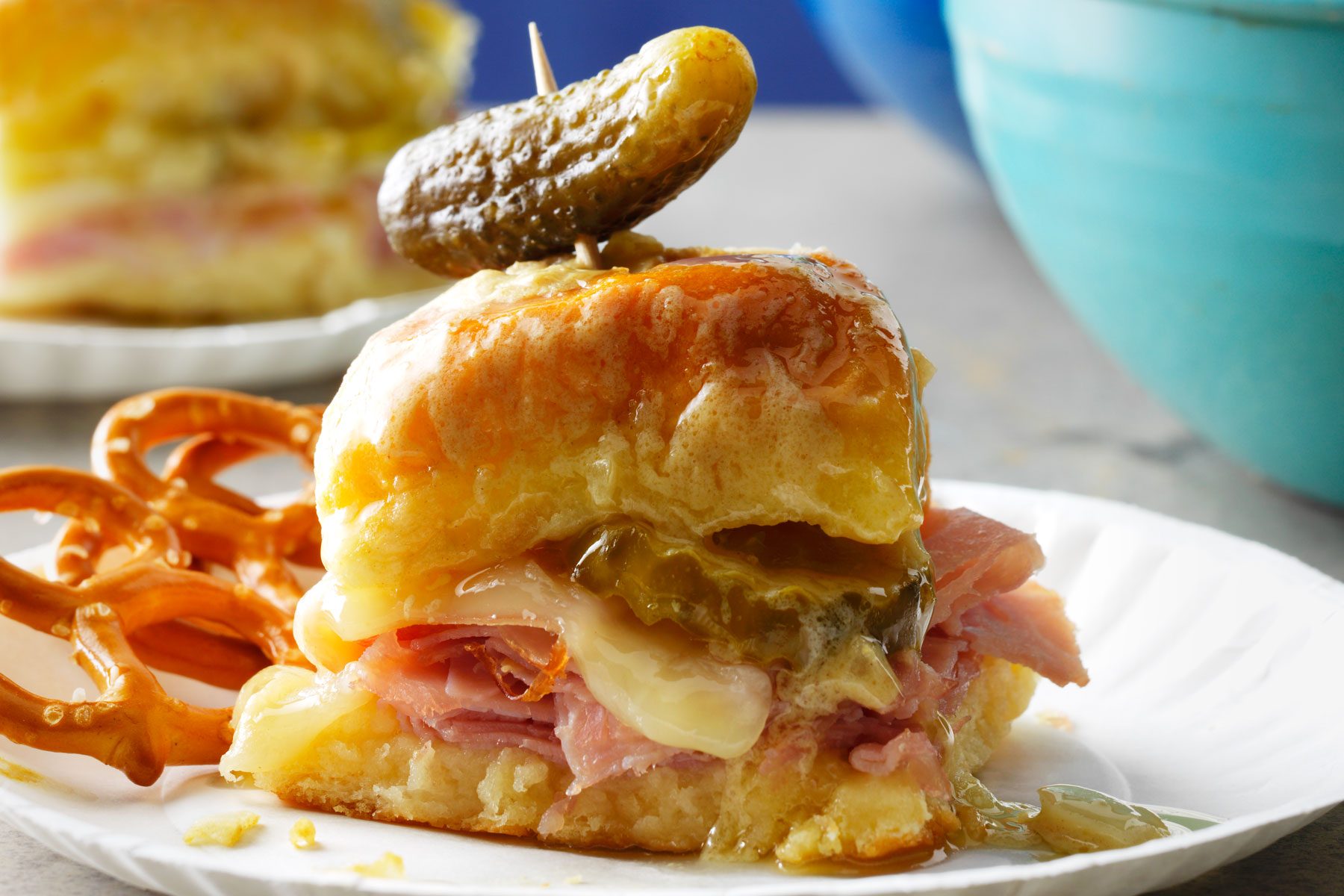 Cuban Sliders with onion rings served in a small plate