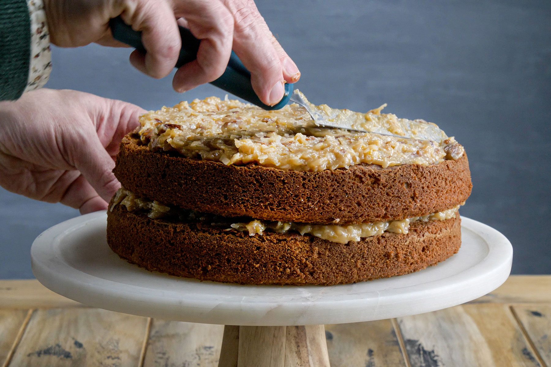 A person Frosting the cake with a spatula