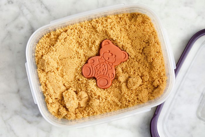 Terracotta bear in a container of brown sugar