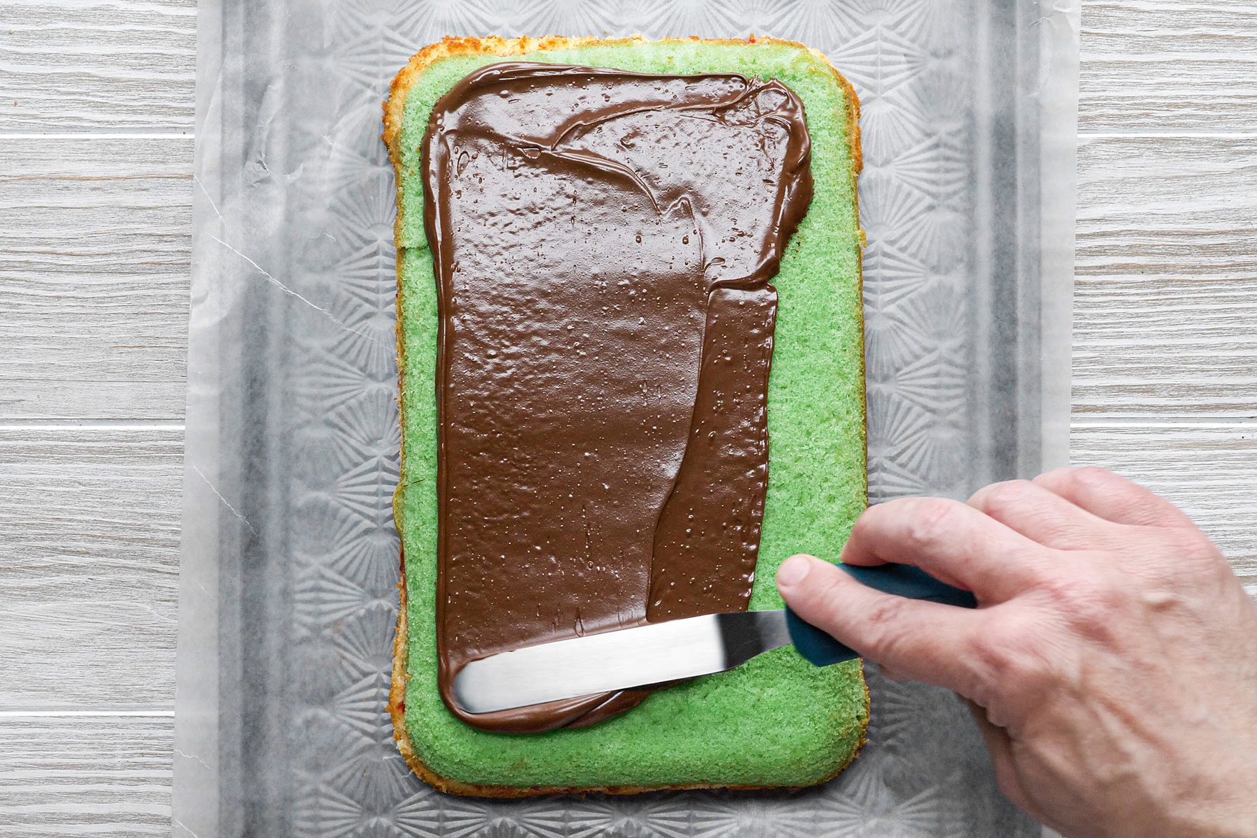 Spreading chocolate glaze on cake