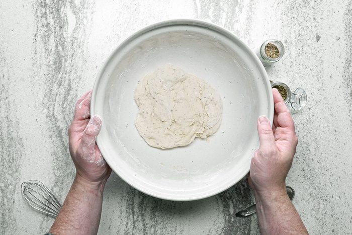 Pizza dough resting in large bowl