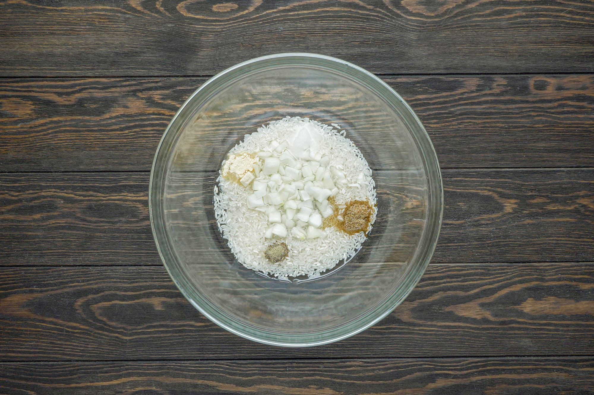 Combine the uncooked rice, water, chopped onion, salt, celery salt, pepper and garlic powder in a large bowl