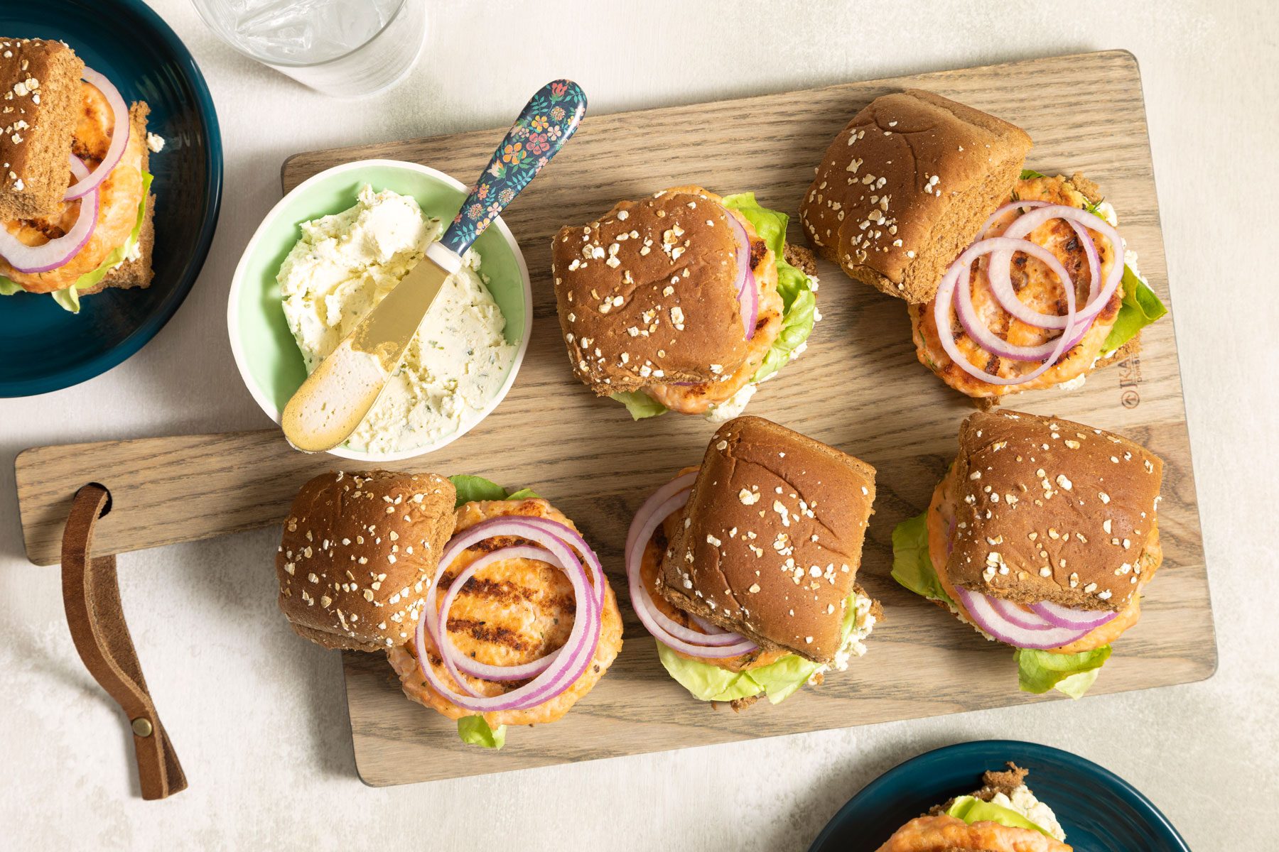 Salmon Sliders served with whote sauce on a wooden plate