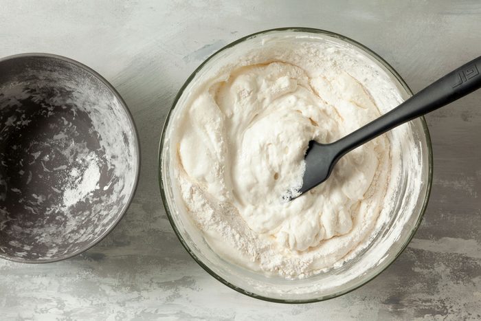 Flour and cream mixed inside a bowl on a kitchen countertop