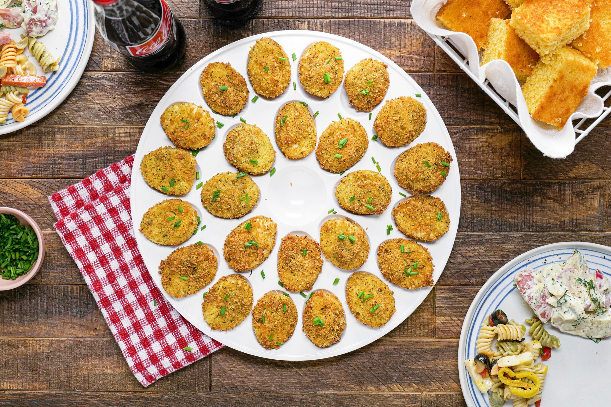 A plate of Deep-Fried Deviled Eggs placed on a table garnished with fresh chives