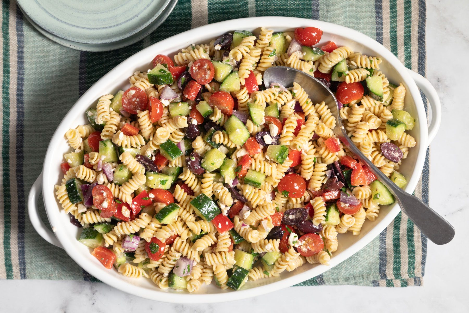 Greek Pasta Salad in a plate served on a kitchen countertop