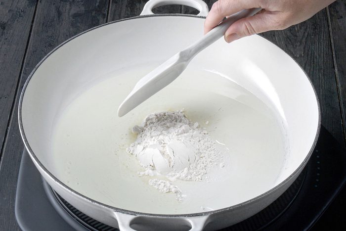 Stirring flour in large skillet over heat