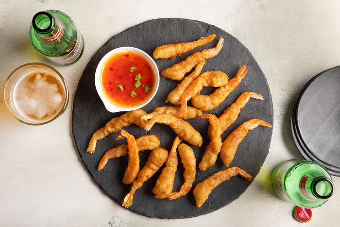 Shrimp Tempura served on plate with sauce and beverages on side