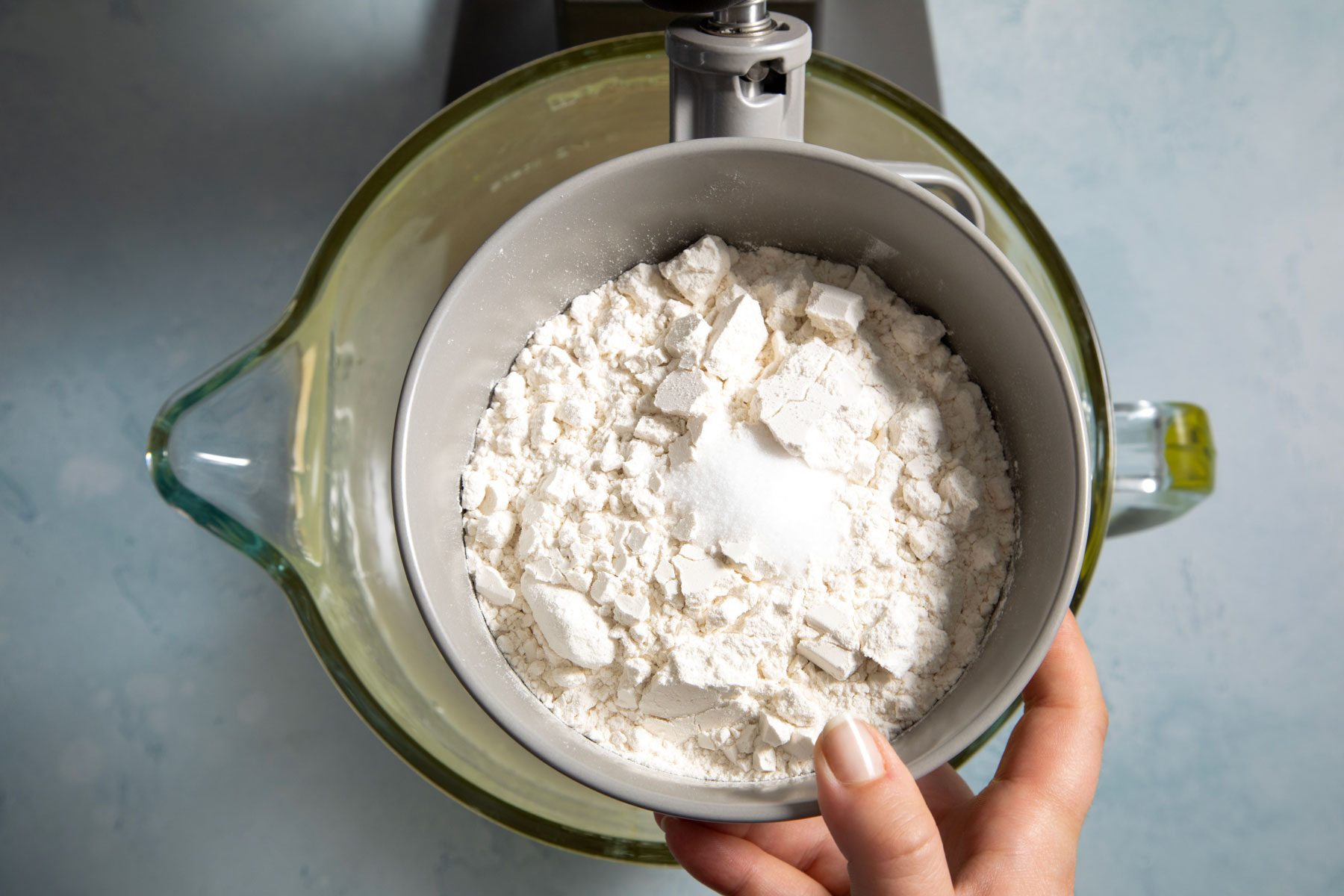 Holding a large bowl filled with flour 