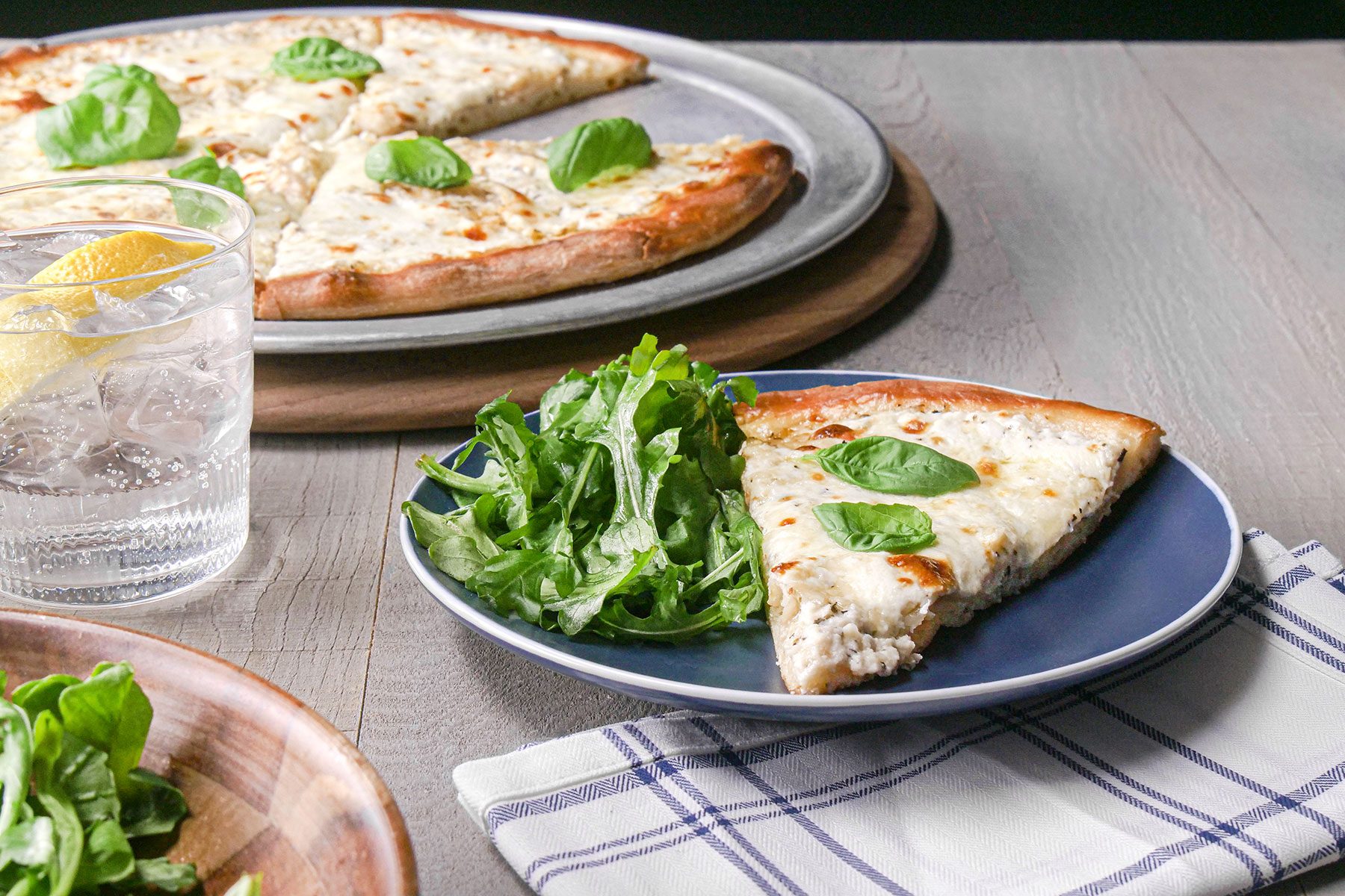 White Pizza served on plate with drinks on side