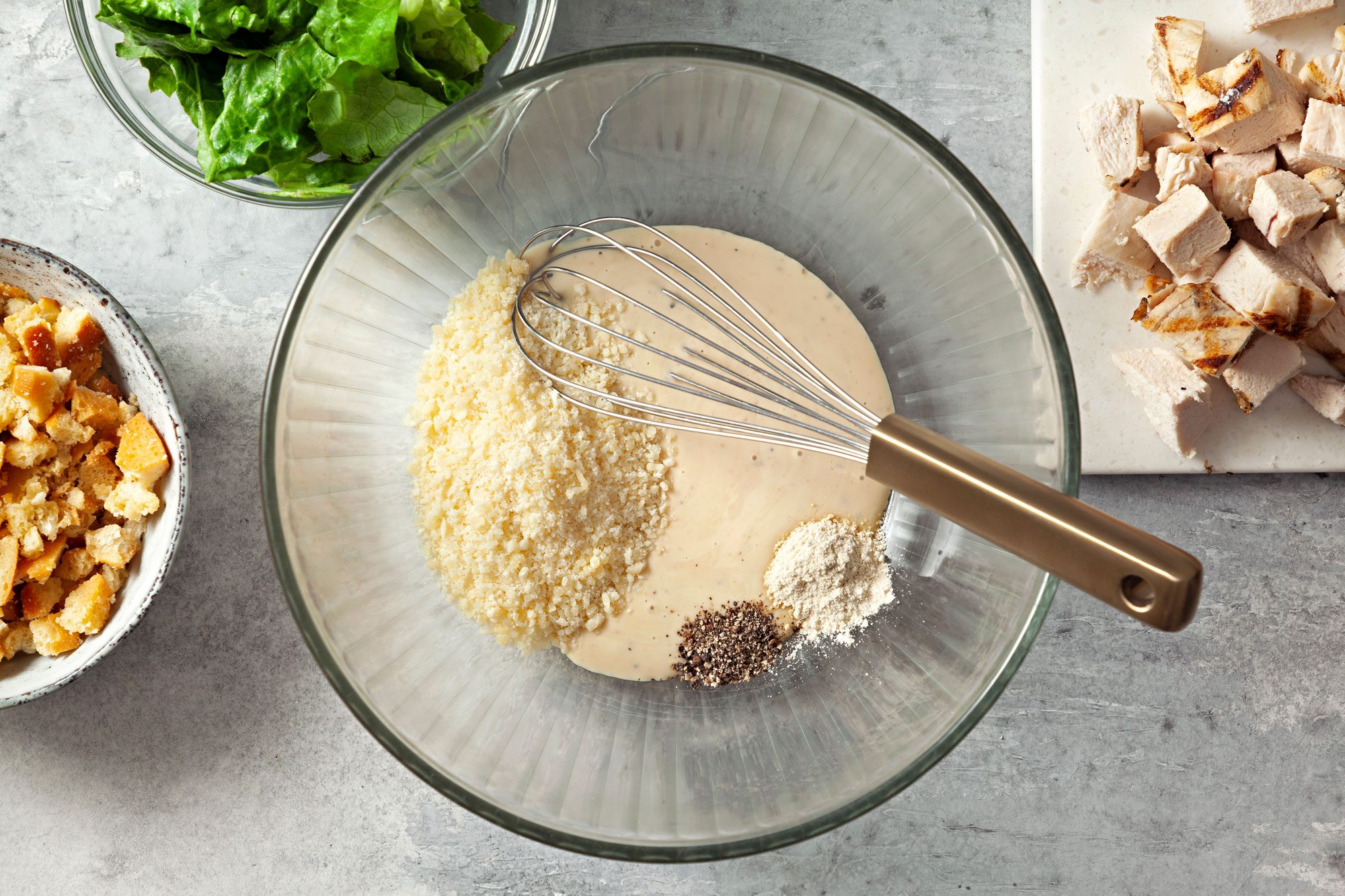 overhead shot of dressing combined with cheese, garlic powder and pepper in a large bowl